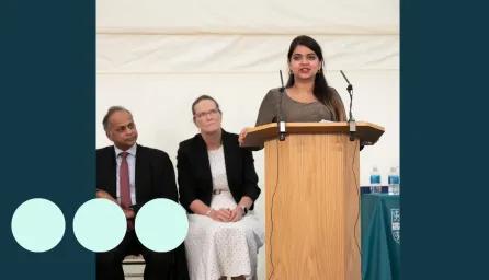 woman stood at podium delivery a speech