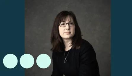 Headshot of woman with dark hair and glasses
