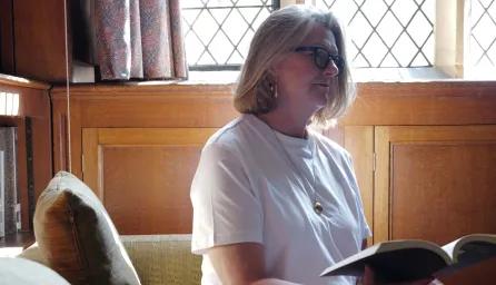 Person sat in library reading open book