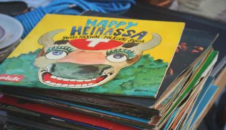 A stack of children’s books with colourful covers, set in front of shelves and background storage items