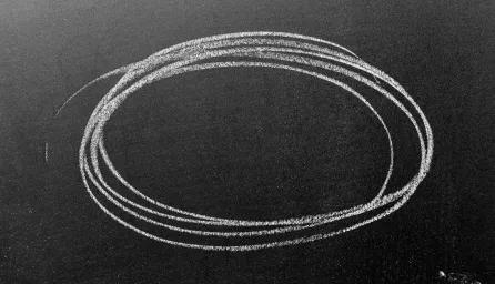 A circle drawn in white chalk on a chalkboard.