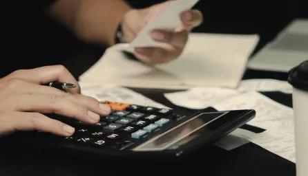 Student with calculator, bills and receipts