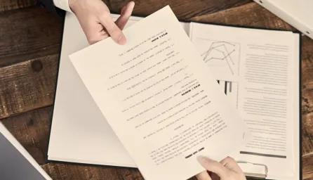 One person passing a document to another person