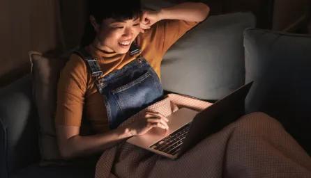 Woman with laptop on sofa 