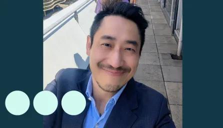 Selfie taken by Asian man, smiling and wearing a suit 