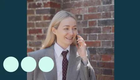 Blonde woman wearing suit, walking and talking on a mobile phone