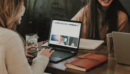 Friends sitting at table with laptops learning online
