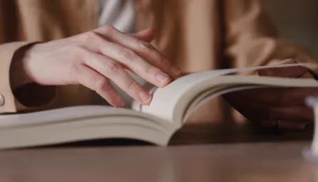 Hands turning pages of a book