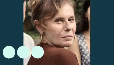 Woman with light brown hair tied up, looking over her shoulder for photo