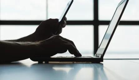 Student logging into a laptop with phone