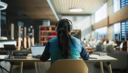 Student at desk with headphones on