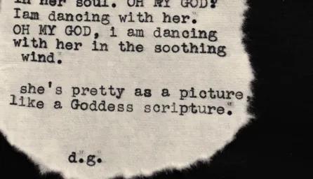 a piece of text, likely a poem or short verse, printed or typed on a torn or irregularly shaped piece of fabric, possibly linen or cotton. 