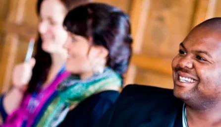 3 people listening to a seminar at a coaching group workshop.