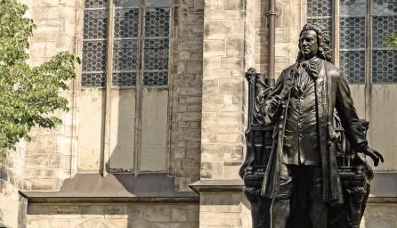 A bronze statue of Johann Sebastian Bach stands in front of St. Thomas Church in Leipzig, Germany. 