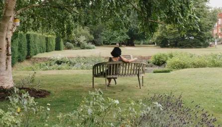 A student relaxing in Newnham College gardens.