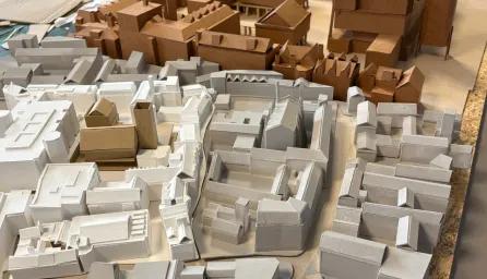 A close-up of an architectural model of an urban or town layout in white, grey and brown shot from above.