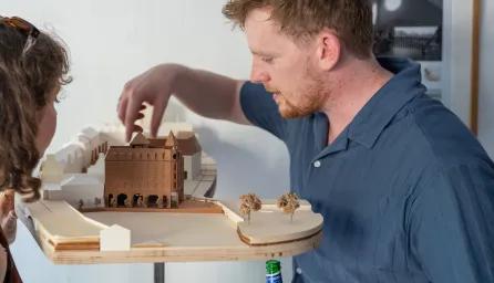 Students and guest looking at building models at the architecture exhibition bition 
