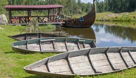Wooden viking boats on river and river bank 