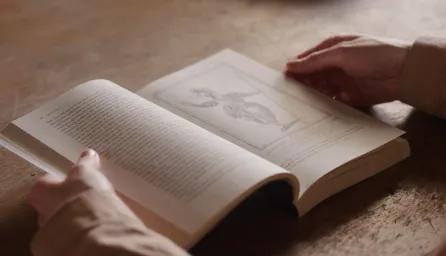 An open book on a wooden table.