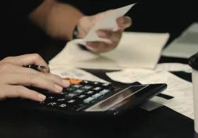 Student with calculator, bills and receipts
