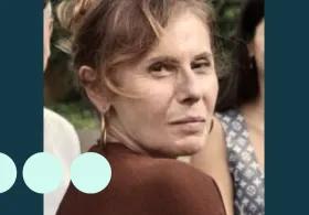 Woman with light brown hair tied up, looking over her shoulder for photo