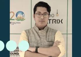 Man with glasses stood with arms folded 