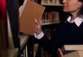 Woman taking a book from a bookshelf