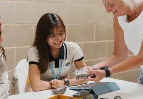 Two students and a course director looking at specimens