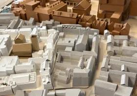 A close-up of an architectural model of an urban or town layout in white, grey and brown shot from above.