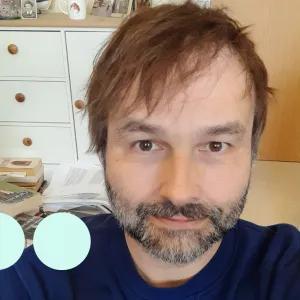 Man with dark hair and greying stubble