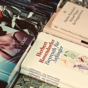 A close-up view of several books scattered on a surface, with German titles visible on their covers.