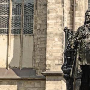 A bronze statue of Johann Sebastian Bach stands in front of St. Thomas Church in Leipzig, Germany. 
