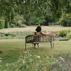 A student relaxing in Newnham College gardens.