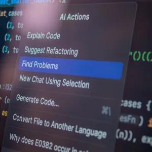 Close up of a computer screen displaying multicoloured computer code, and a pop-up box with AI options for actions.