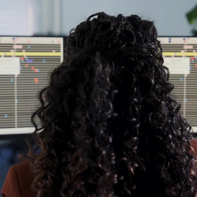 Back of head looking at genomic sequencing on a computer 