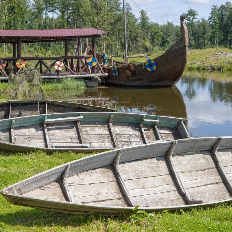 Wooden viking boats on river and river bank 