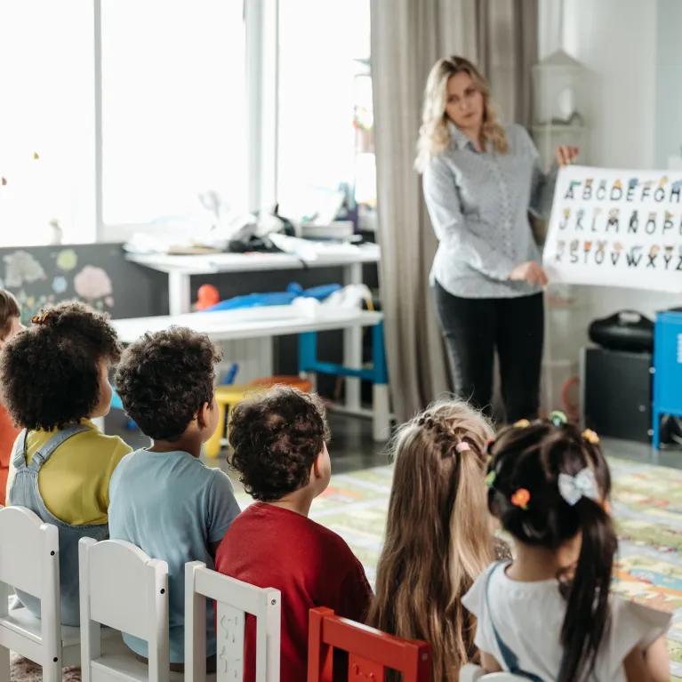 Teachers engage children in learning alphabet during a kindergarten class