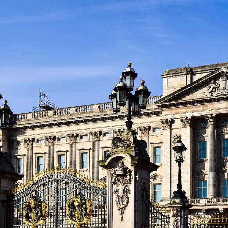 Exterior view of Buckingham Palace in London showcasing its historic architecture and ornate gate