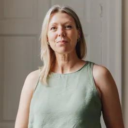 Women smiling looking at camera with sage green top