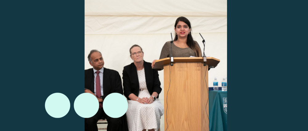 woman stood at podium delivery a speech