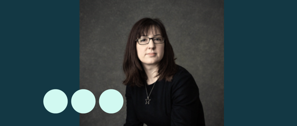 Headshot of woman with dark hair and glasses