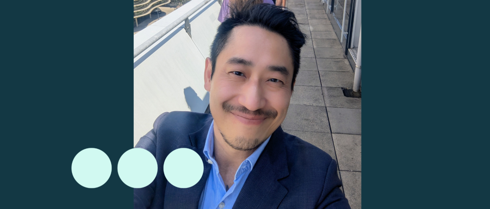 Selfie taken by Asian man, smiling and wearing a suit 