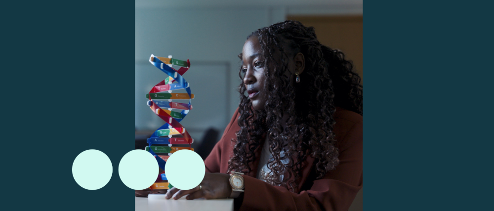 Black woman, sat analysing a DNA model 