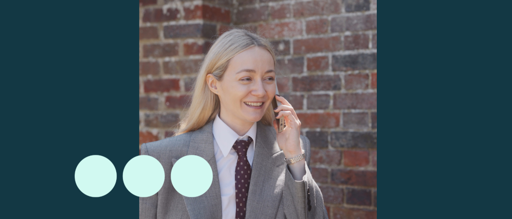 Blonde woman wearing suit, walking and talking on a mobile phone
