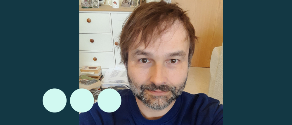 Man with dark hair and greying stubble